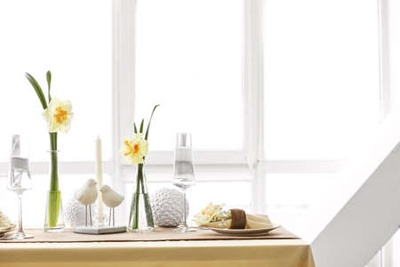 Beautiful table setting with narcissus flowersの写真素材