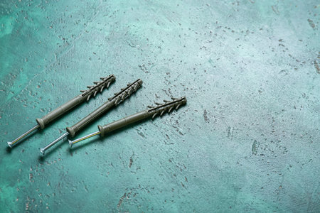 Dowels and wood screws on color background