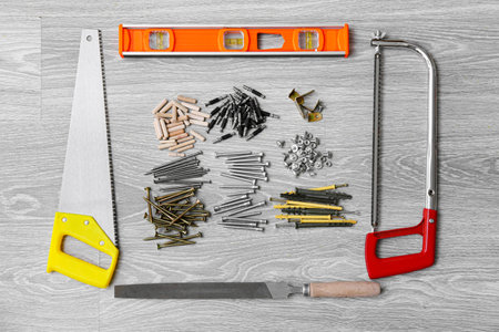 Set of different tools for furniture assembling on gray wooden background