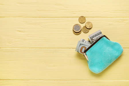 Blue wallet with money on yellow wooden backgroundの写真素材