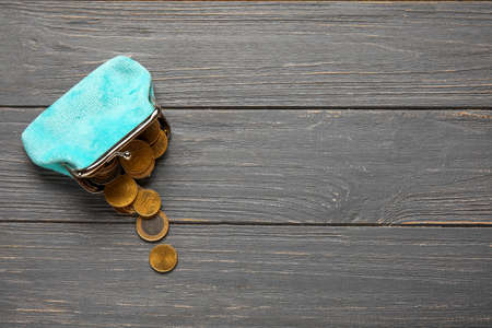 Blue wallet with coins on dark wooden background