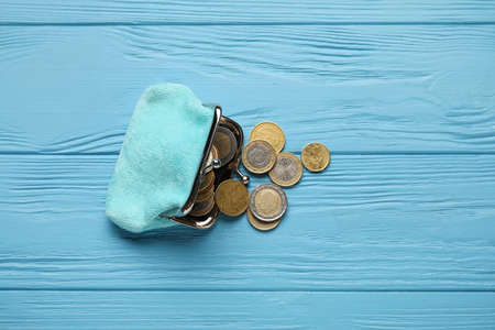 Small wallet with coins on blue wooden backgroundの写真素材