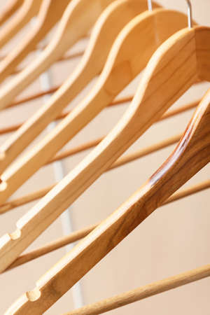 Wooden clothes hangers on light background, closeup
