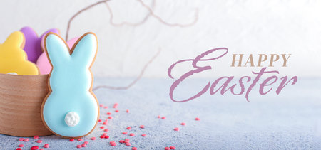 Box with tasty Easter cookies in shape of bunny on light background