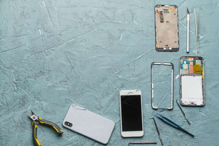 Disassembled mobile phones with technician tools on color backgroundの写真素材