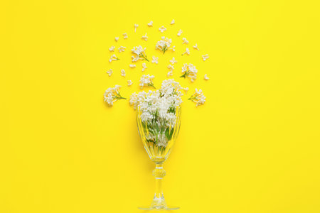 Glass with beautiful lilac flowers on color backgroundの写真素材
