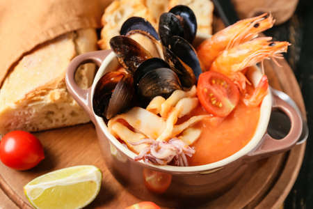 Pot of tasty Cacciucco soup on tableの写真素材