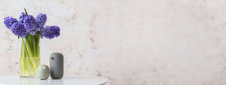 Vase with beautiful hyacinth flowers on table against grunge background with space for textの写真素材
