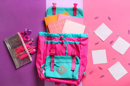 School backpack with stationery on color backgroundの写真素材