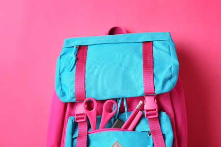 School backpack with stationery on color backgroundの写真素材
