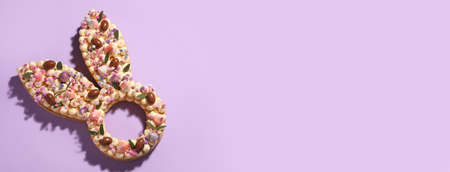Beautiful cake for Easter celebration on lilac background with space for textの写真素材