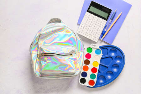 School backpack with stationery on light backgroundの写真素材