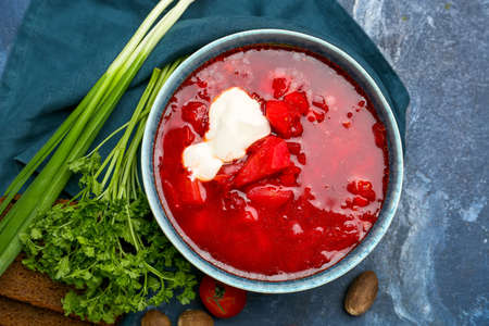 Bowl of tasty borscht with sour cream on color backgroundの写真素材