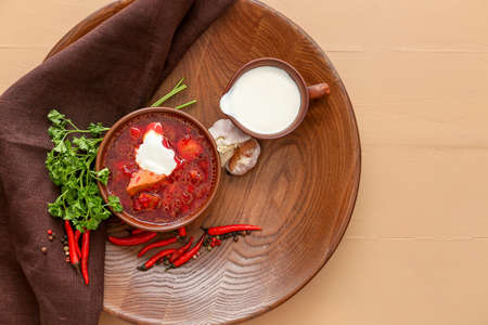 Bowl with tasty borscht and sour cream on color wooden backgroundの写真素材