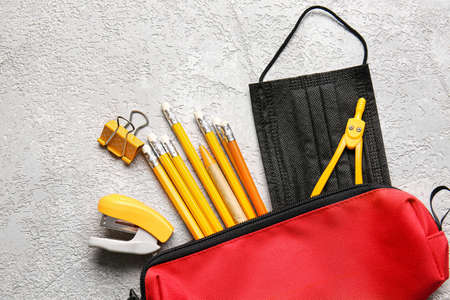 Pencil case with stationery and medical mask on grunge backgroundの写真素材