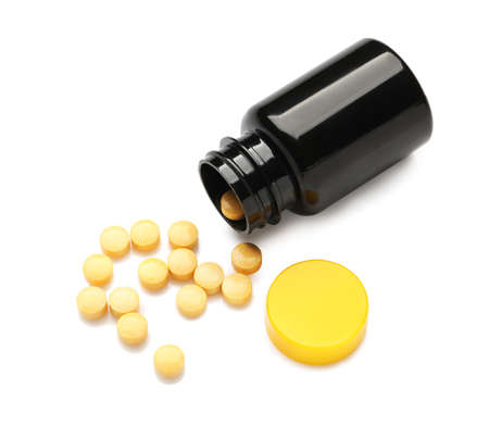Bottle with yellow pills on white backgroundの写真素材