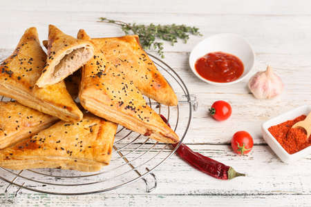Cooling rack with tasty Uzbek samsa on table