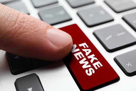 Man pressing key with text FAKE NEWS, closeup