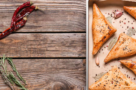Baking tray with tasty Uzbek samsa on wooden backgroundの写真素材