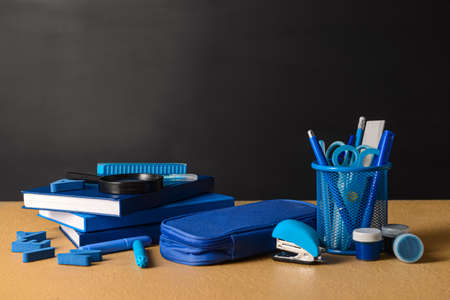 Set of colorful stationery with magnifier on table against dark backgroundの写真素材