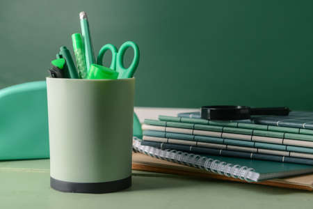Holder with stationery, notebooks and magnifier on table, closeupの写真素材