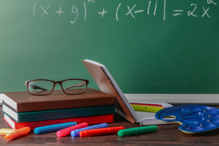 Different stationery and eyeglasses on the table in the classroomの写真素材