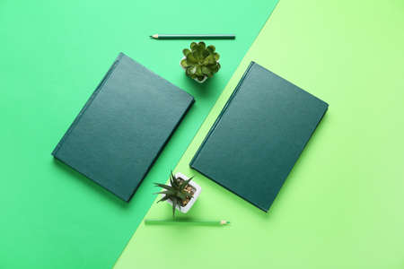 Composition with notebooks, pencils and houseplants on color backgroundの写真素材
