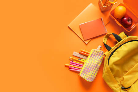 Different stationery, backpack and fruits on color backgroundの写真素材