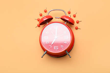 Alarm clock and pins on color backgroundの写真素材
