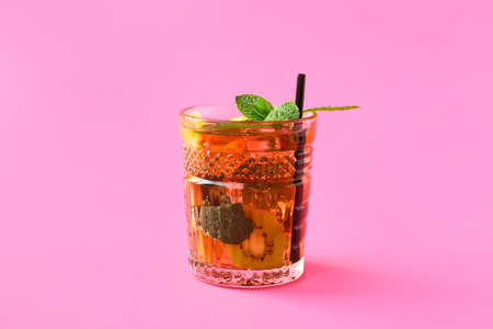 Glass of tasty ice tea with fruits on color backgroundの写真素材