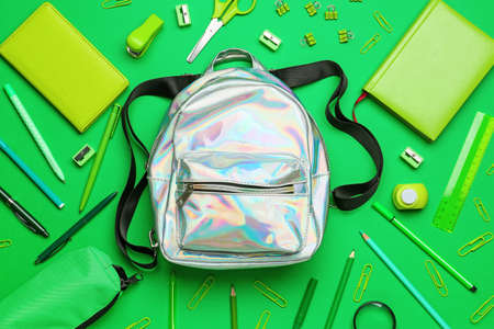 Stylish backpack and stationery on green backgroundの写真素材