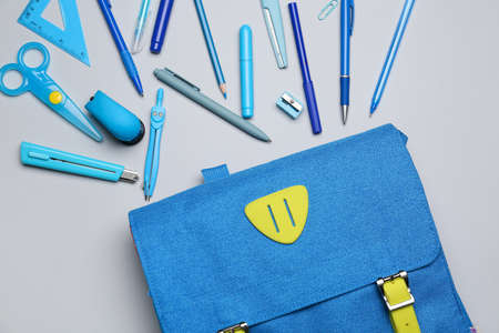 School backpack and stationery on white background, closeup