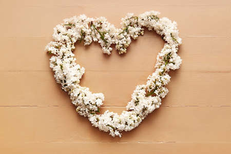 Heart made of beautiful lilac flowers on color wooden backgroundの写真素材