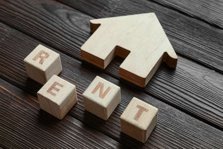 House with word RENT on dark wooden background, closeupの写真素材