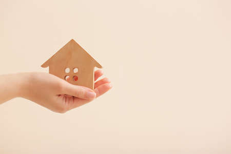Woman with wooden house on light backgroundの写真素材