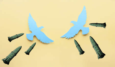Paper doves with drawn missiles on color background. War in Ukraineの写真素材