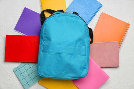 School backpack and notebooks on light backgroundの写真素材