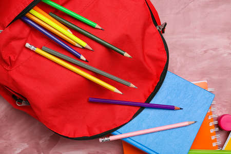 School backpack and stationery on color backgroundの写真素材