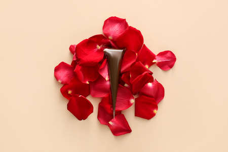 Henna paint and rose petals on beige background