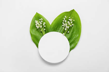 Beautiful lily-of-the-valley flowers and blank card on white background