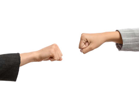 Hands of businesswomen with clenched fists on white background