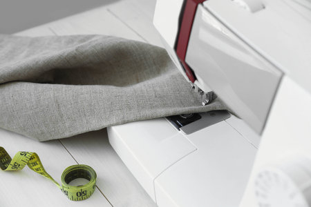 Sewing machine with cloth and measuring tape on table, closeupの写真素材