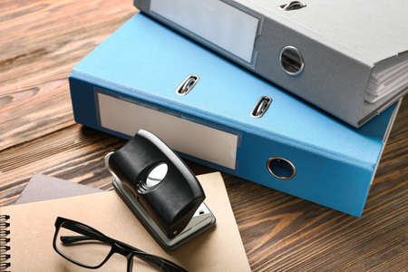 Office folders and stationery on wooden background