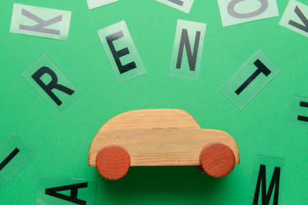 Word RENT with wooden car on green backgroundの写真素材