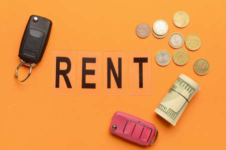 Word RENT with car keys and money on orange backgroundの写真素材