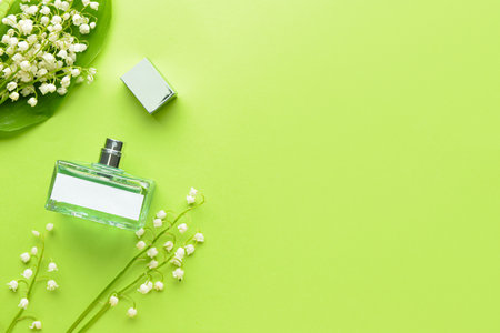 Bottle of perfume and lily-of-the-valley flowers on color backgroundの写真素材