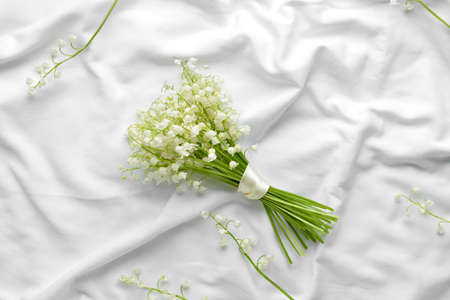 Beautiful lily-of-the-valley flowers on light fabric backgroundの写真素材