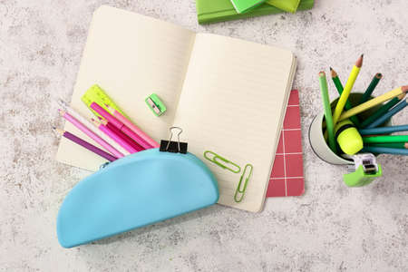 Pencil case with stationery on light background