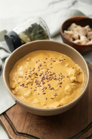 Bowl of tasty chicken curry on light background
