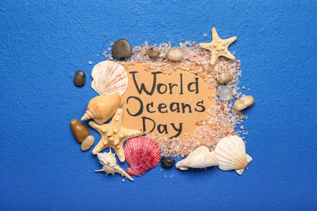 Paper sheet with text WORLD OCEAN DAY and sea shells on color backgroundの写真素材